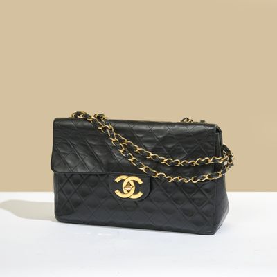 un sac Chanel noir auquel est suspendue une chaîne dorée