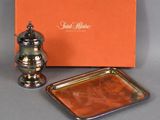 an orange box with a silver tray and a silver pepper shaker