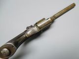 a close up of a gun with a wooden handle on a table