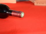 a bottle of wine sitting on a table with a red table cloth