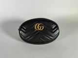 a black gucci bag with a gold gg logo on the front