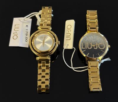 deux montres en or posées l'une à côté de l'autre sur une surface noire