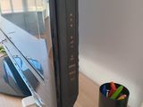 a computer monitor sitting on a desk with a cup of pens and pencils