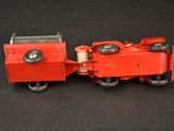 a small red toy train on a black surface