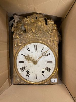 a gold clock in a cardboard box that is open