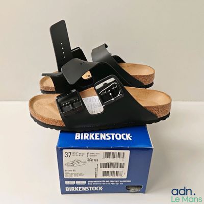 une paire de sandales noires posées sur une boîte