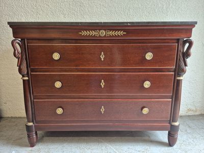 une commode en bois surmontée de ferrures en laiton