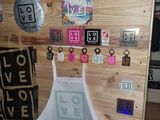 a white apron hanging on a wooden wall with stickers and magnets