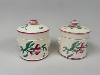 une paire de petits récipients en céramique ornés de fleurs sur un fond blanc