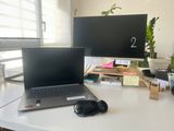 un ordinateur portable posé sur un bureau, à côté d'un écran