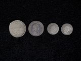 four different coins are shown in a row on a black surface
