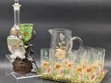 un pichet en verre et un plateau sur lequel sont posés des verres