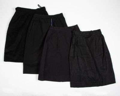 three black skirts are lined up against a white background