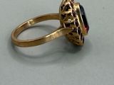 an image of a gold ring with a red stone in the center
