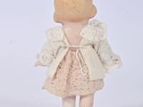 a small doll that is standing on a white surface