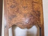 a wooden chair with a leather seat in a room