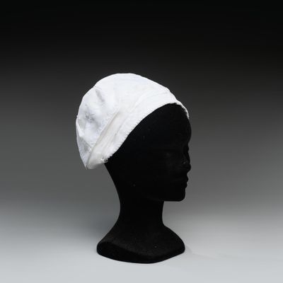 une image représentant une tête de mannequin noire coiffée d'un chapeau blanc