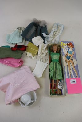 beaucoup de vêtements et une poupée dans une boîte posée sur une table