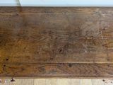 an old wooden table with a wooden top on a hard wood floor