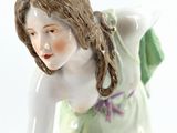 a figurine of a woman in a green dress