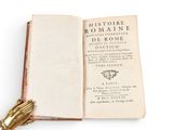 an open book with a gold hand resting on top of it
