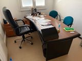 a desk with a chair and a laptop on it