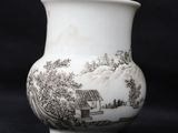 a white vase with black designs on it on a black background