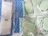 many pieces of green and white items in plastic bags