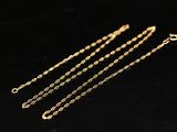 three gold chains on a black surface