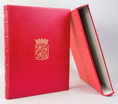 un livre rouge orné d'un blason doré sur la couverture