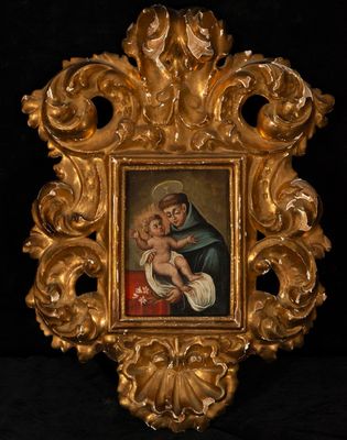 an ornate gold frame with a painting of a woman holding a child