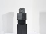 une pile de blocs noirs posée sur une surface blanche