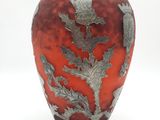 un vase rouge orné d'un motif argenté