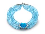 un gros plan d'un bracelet orné d'une pierre bleue