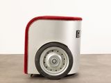 a white and red suitcase with wheels on a concrete floor