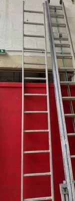 deux échelles situées à côté d'une porte rouge