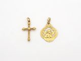 une petite croix en or et une petite médaille en or sur fond blanc