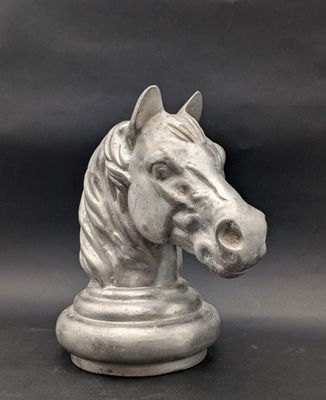 une statue représentant une tête de cheval posée sur un socle