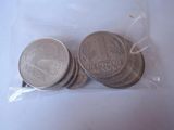 four coins in a plastic bag on a white surface
