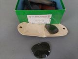 a green box with a pair of black stones in it