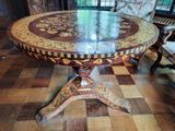 a round table with a marble top on a checkered floor
