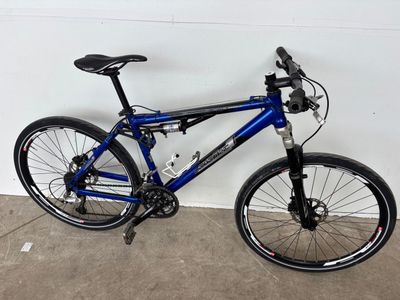 un vélo bleu garé dans un garage, près d'un mur blanc