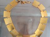 a gold necklace on display in a glass case