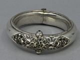 an antique silver bracelet with a flower design on the side