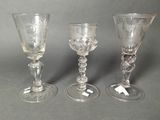 three glass goblets sitting next to each other on a table