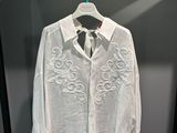 une chemise blanche et une cravate suspendues à un cintre dans une armoire
