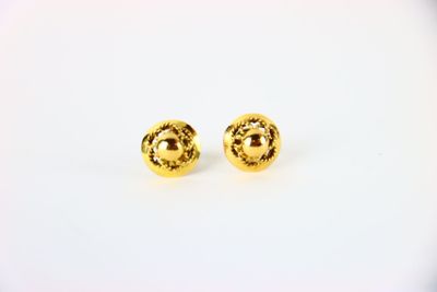 une paire de boucles d'oreilles en or sur fond blanc