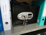 a safe box on a shelf with a bunch of folders