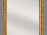 un grand miroir à cadre doré orné d'un motif décoratif