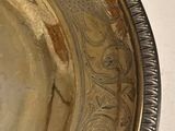 two silver plates on a white table with a silver spoon